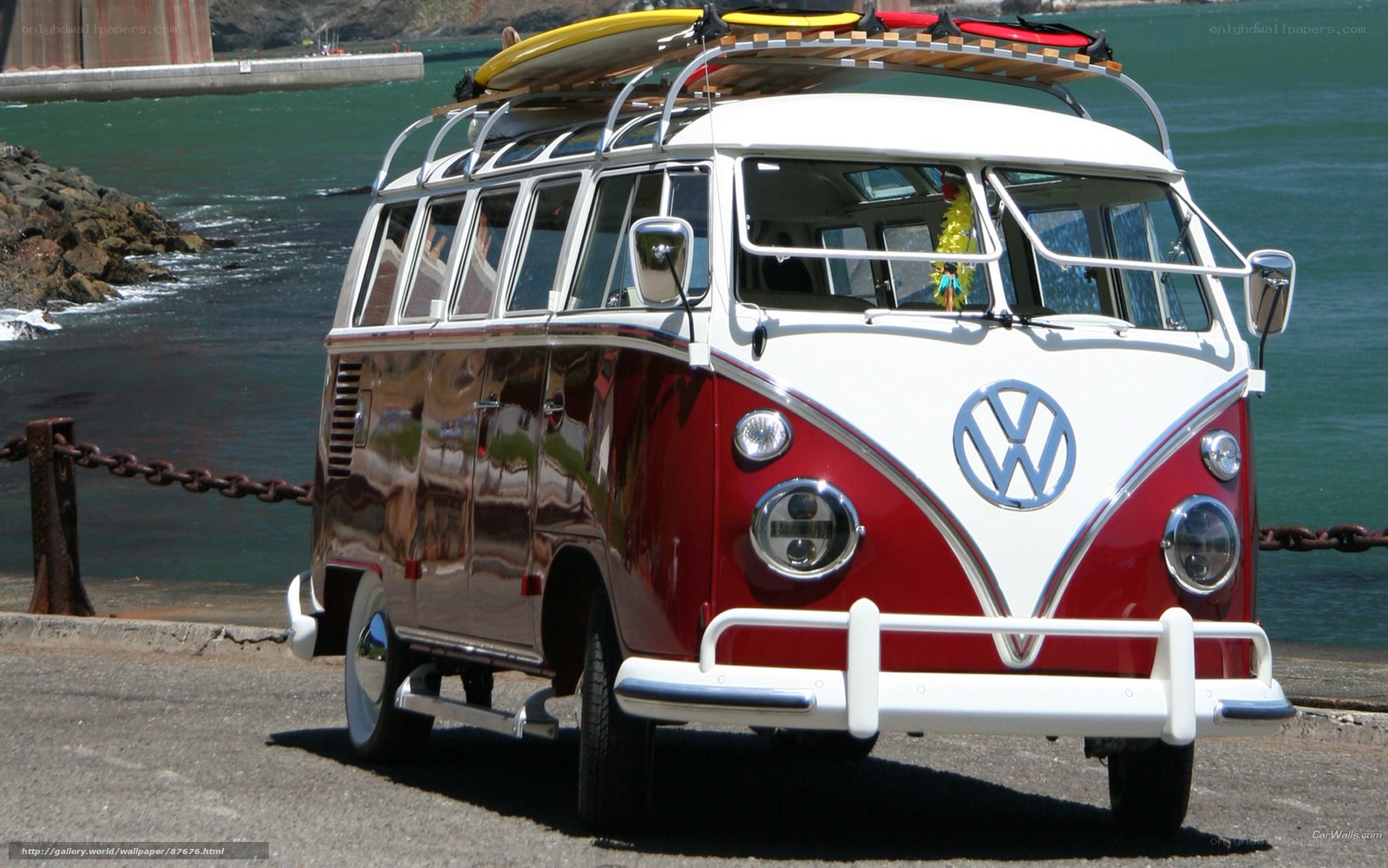 Red and white VW bus by the water