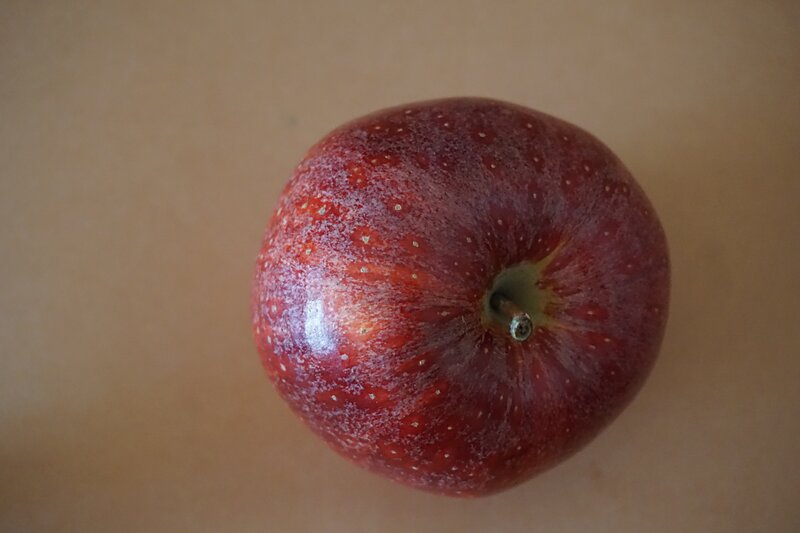 red apple on brown surface