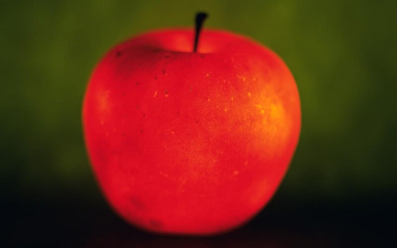 Red apple on green background