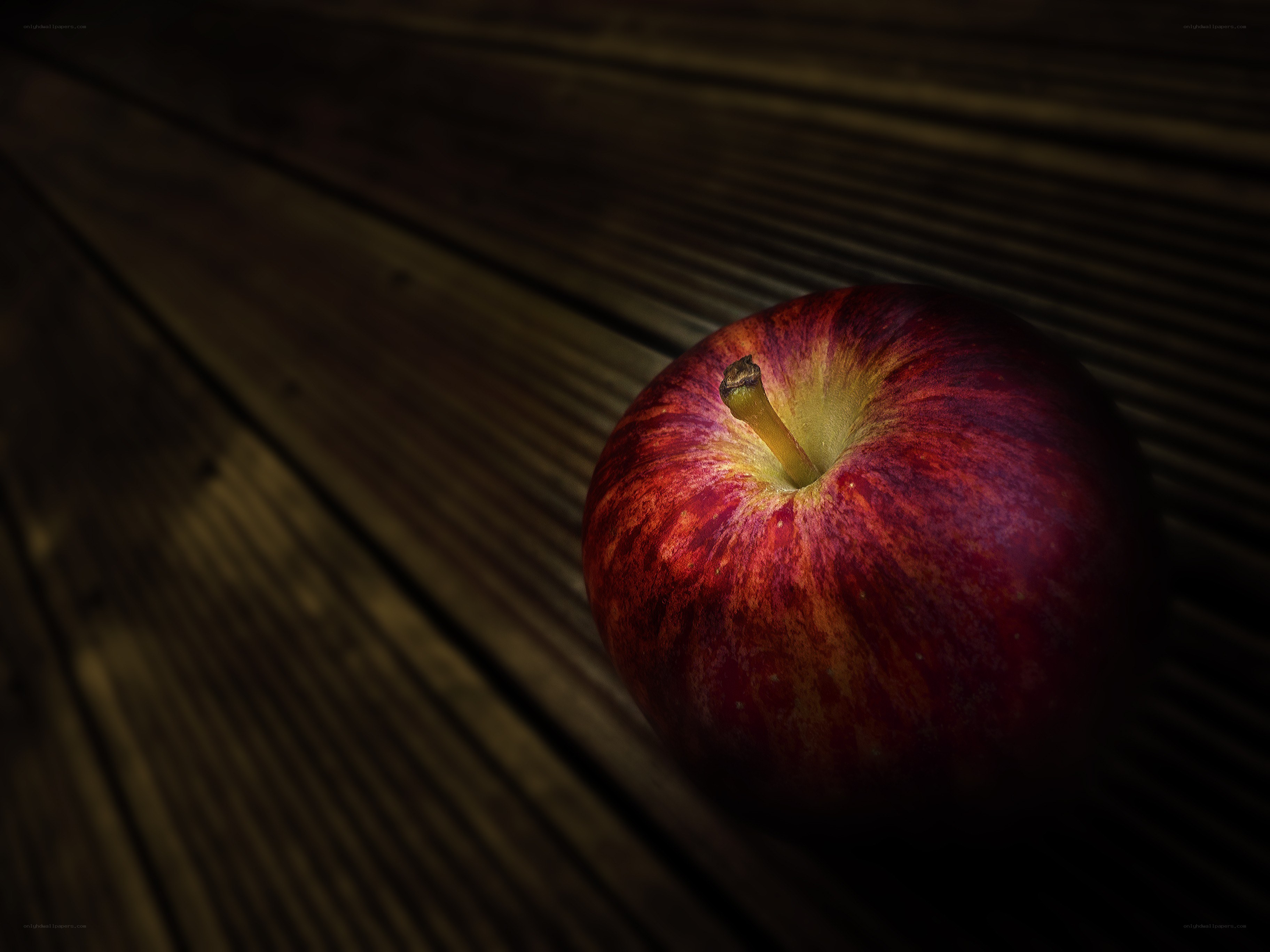 Red apple on wooden surface