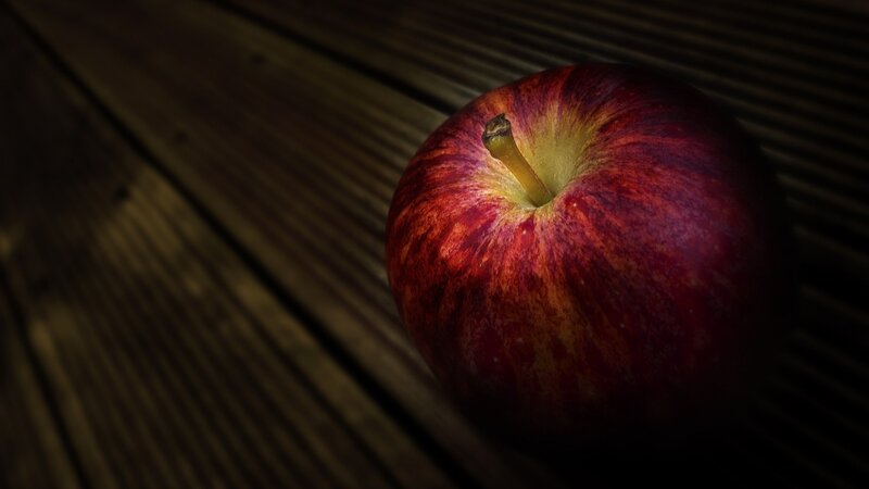 red apple on wooden surface