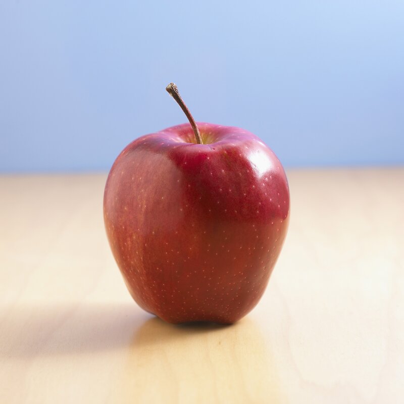 red apple on wooden surface