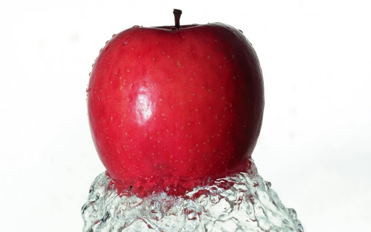 Red apple splashing in water