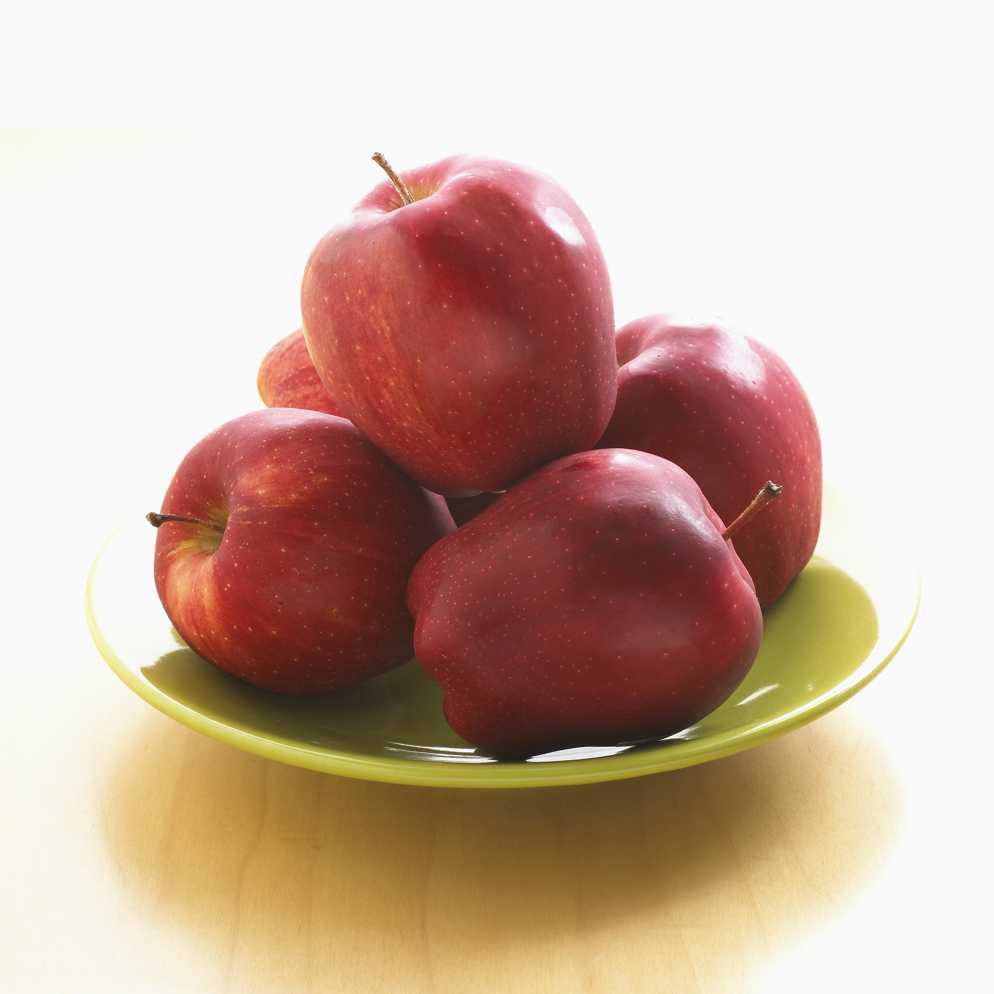 Red apples on a green plate