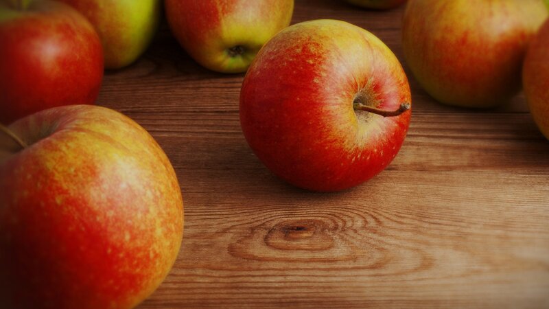 red apples on wooden surface
