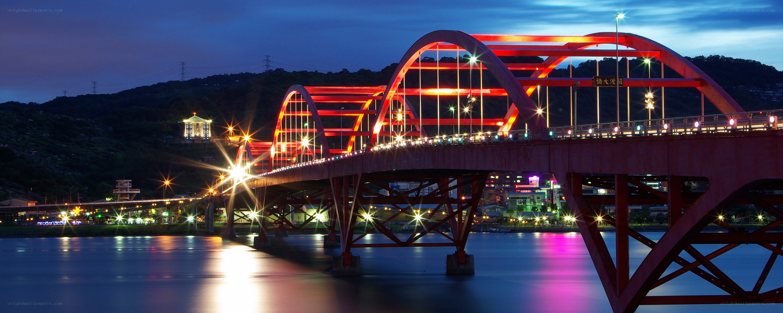 Red arched bridge at night
