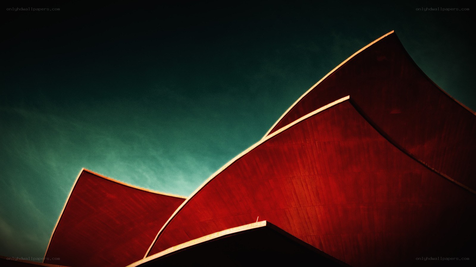 Red architectural curves against teal sky