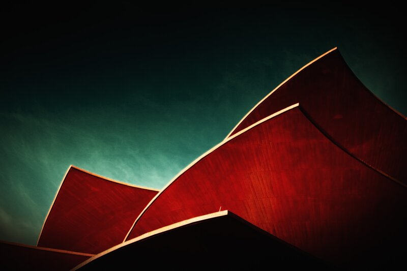 Red architectural curves against teal sky