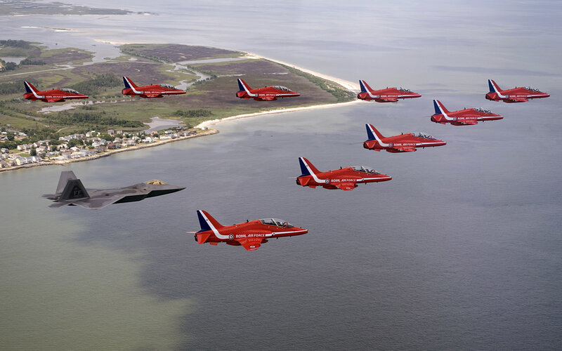 Red Arrows and F-22 over coastline