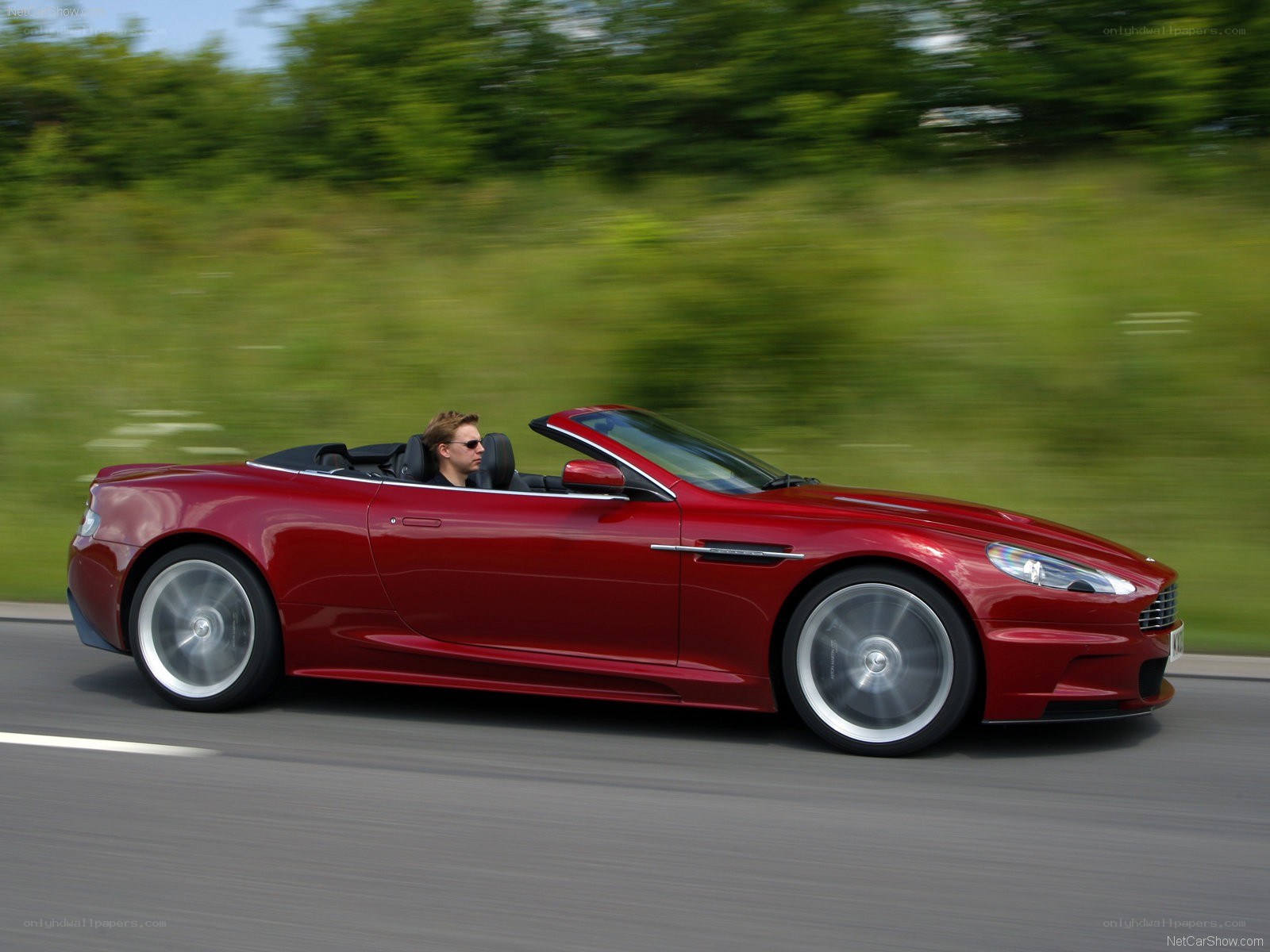 Red Aston Martin convertible in motion