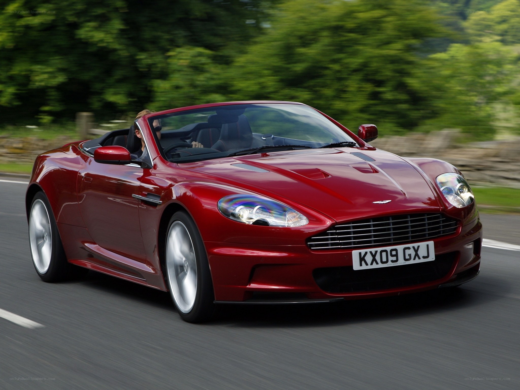 Red Aston Martin convertible in motion