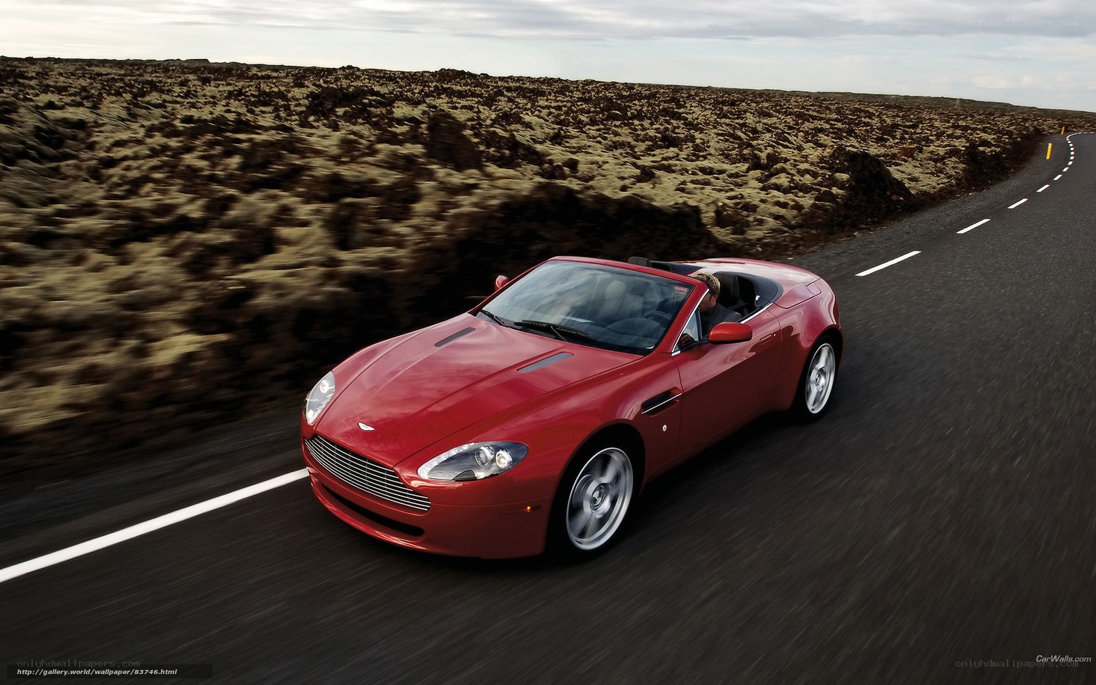 Red Aston Martin convertible on road