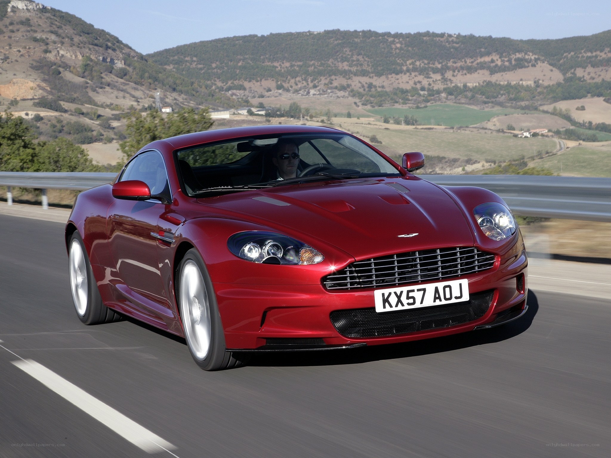 red aston martin driving on road