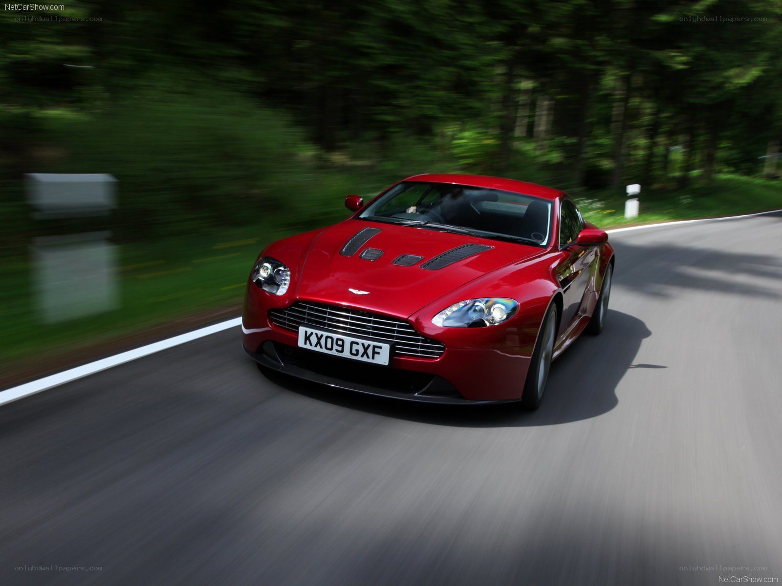 red aston martin driving on road