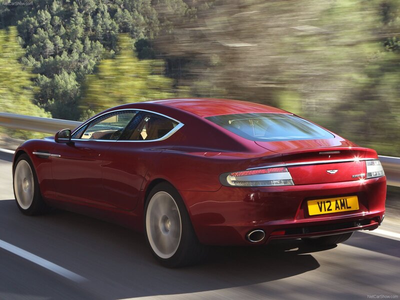 Red Aston Martin driving on road