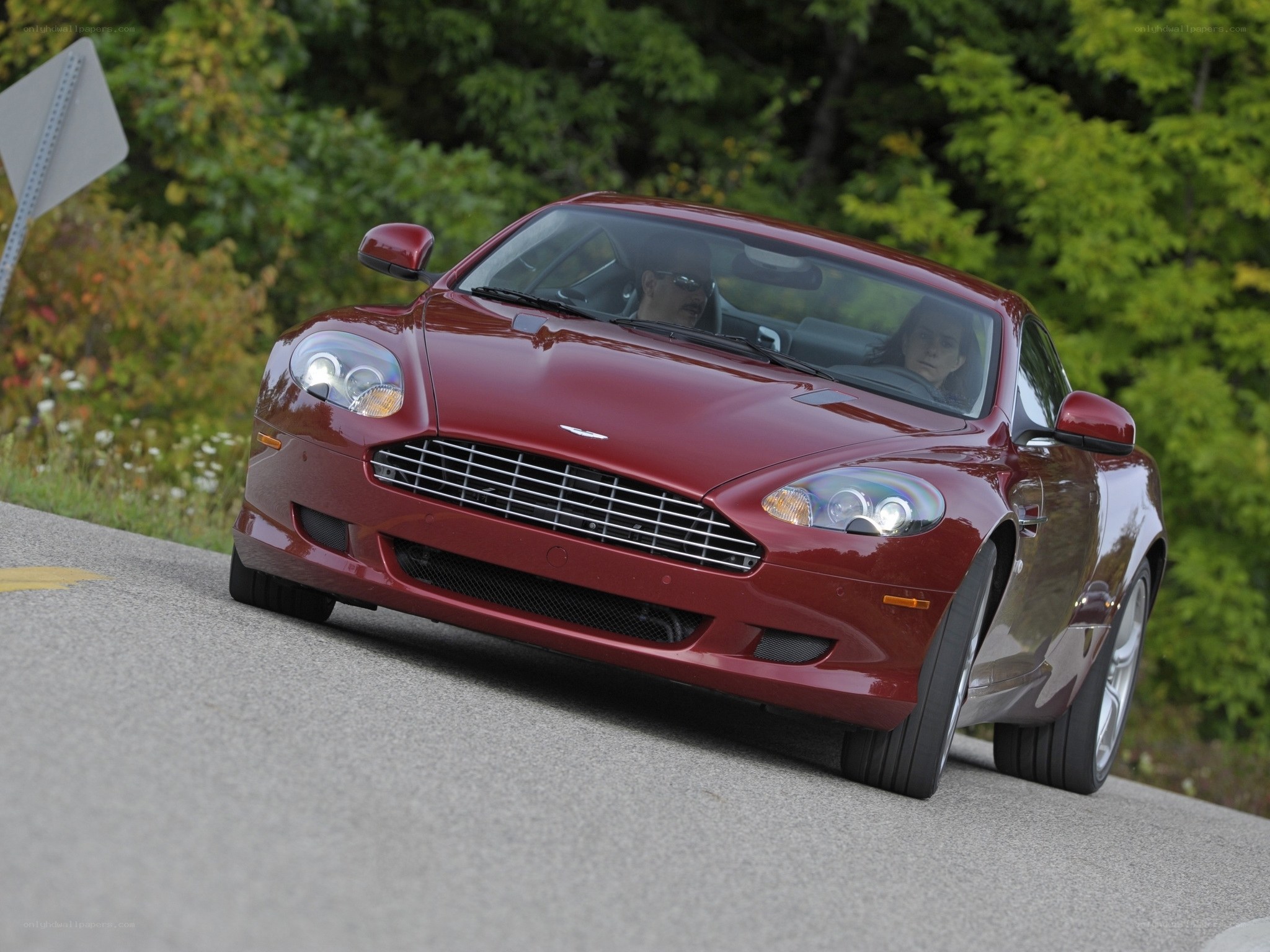 red aston martin driving on road