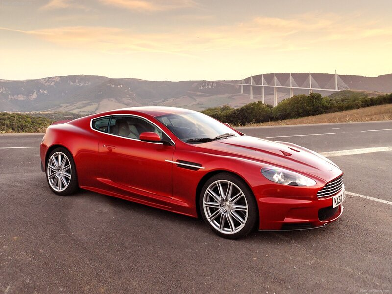 Red Aston Martin on a scenic road