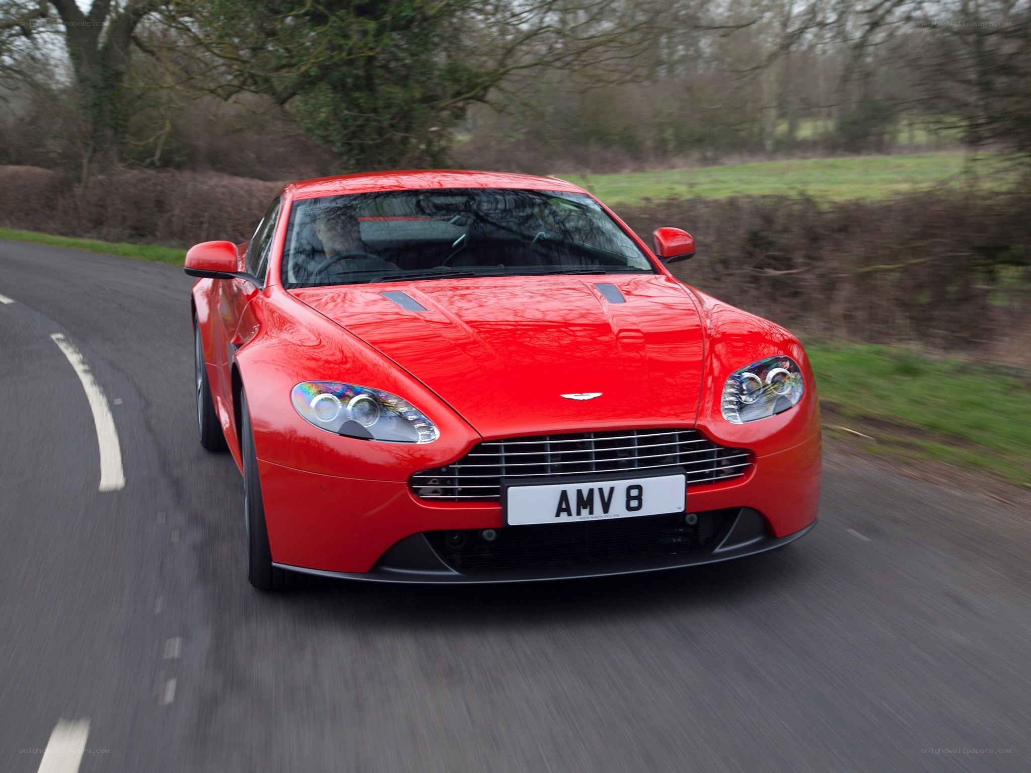 Red Aston Martin on country road