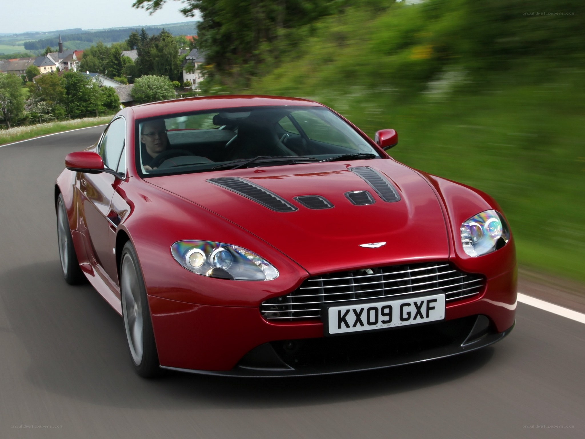 Red Aston Martin on country road