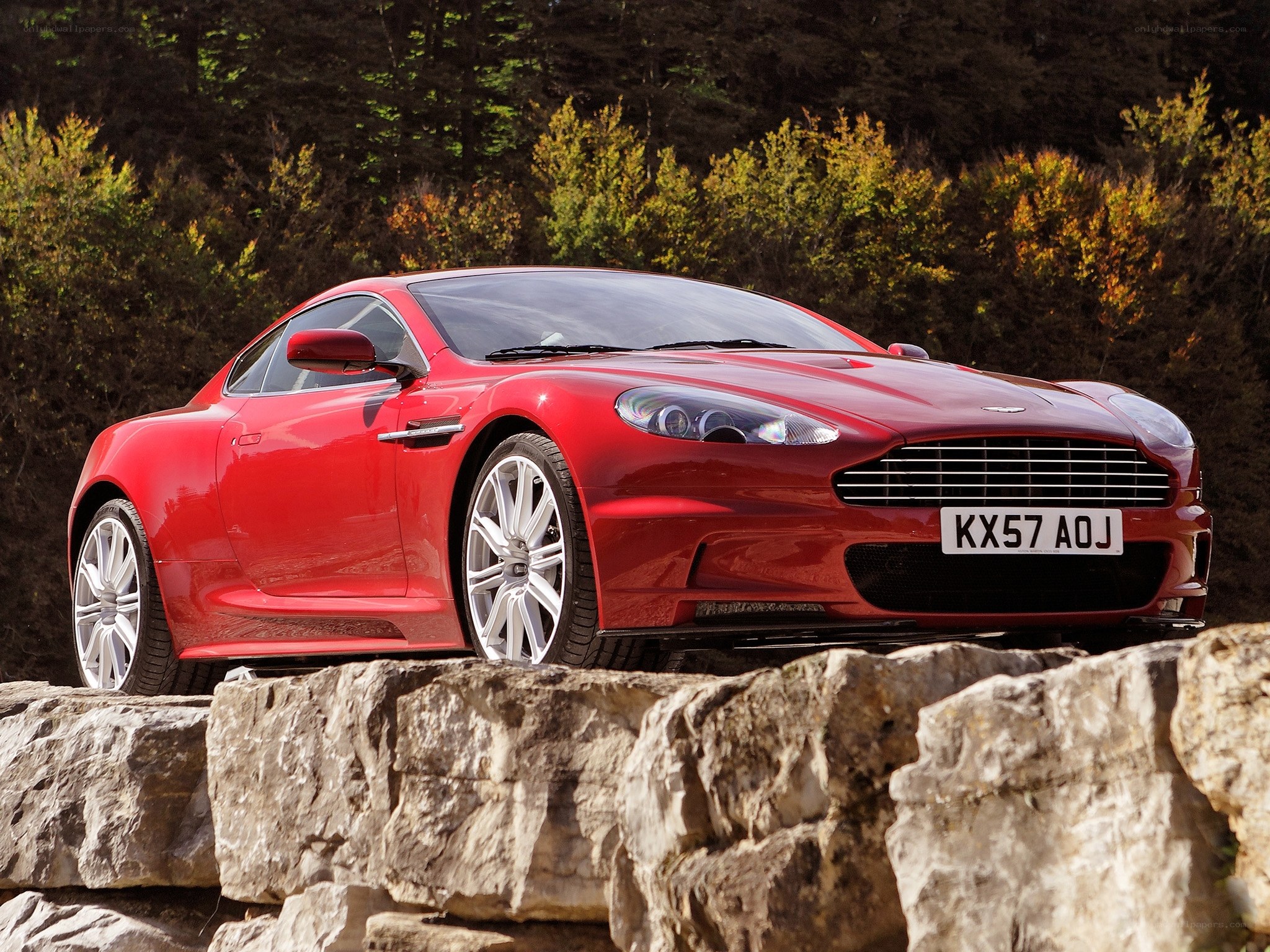 Red Aston Martin on rocks