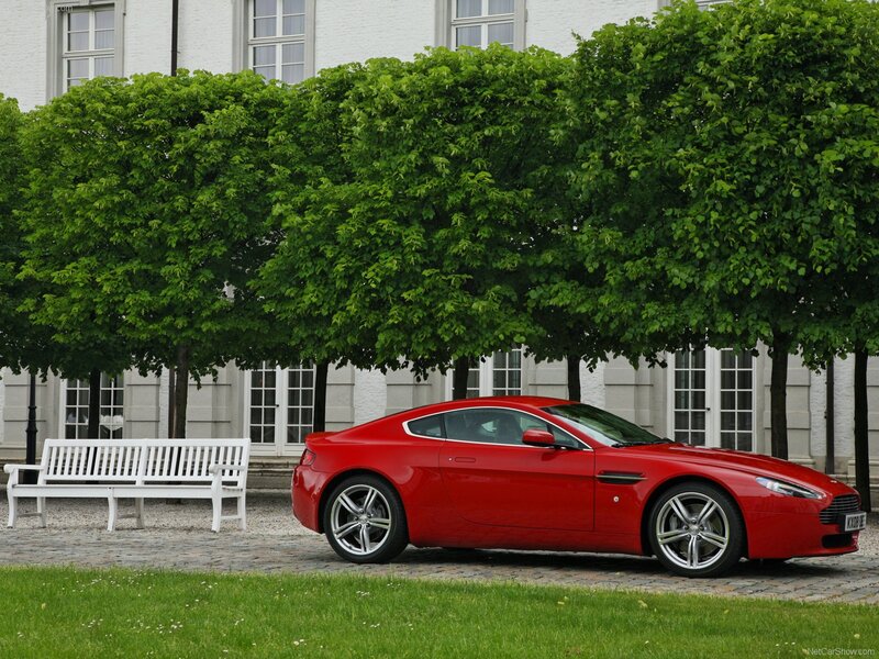 Red Aston Martin parked in garden