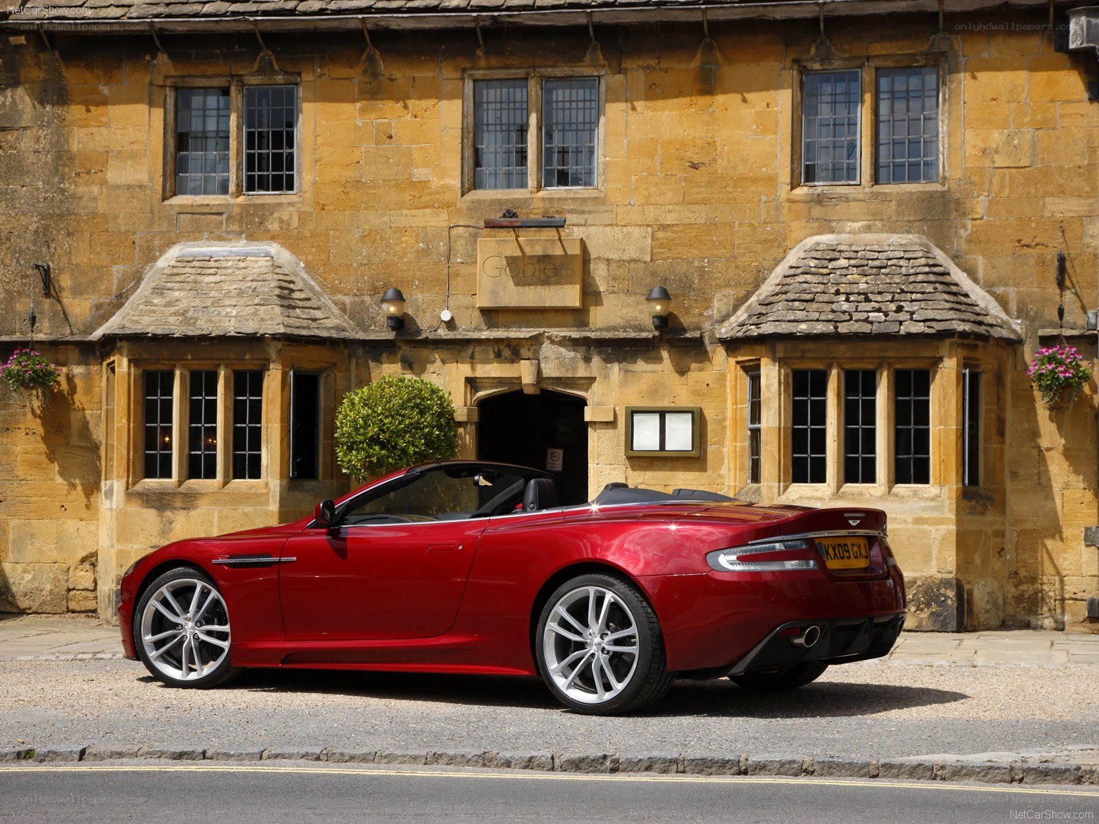 Red Aston Martin parked outside pub
