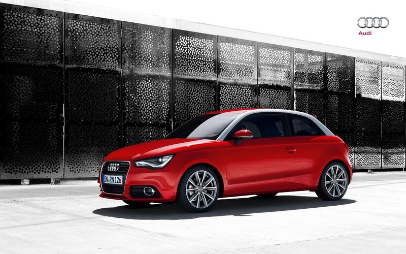 Red Audi A1 parked in front of wall