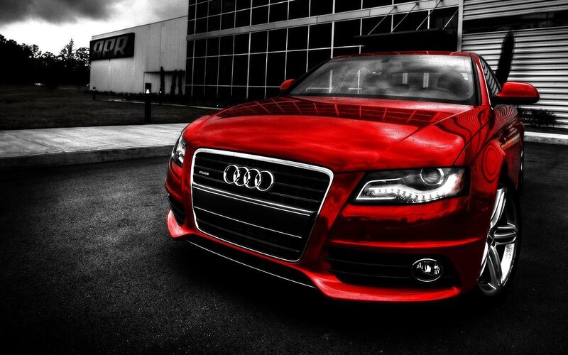 Red Audi car in front of building