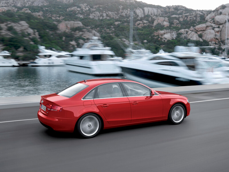 Red Audi driving by a marina