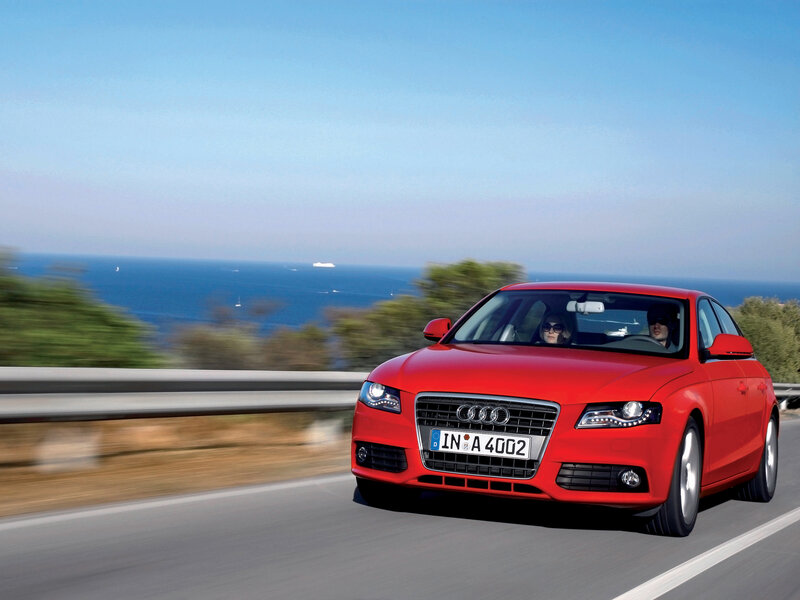 Red Audi driving by the sea