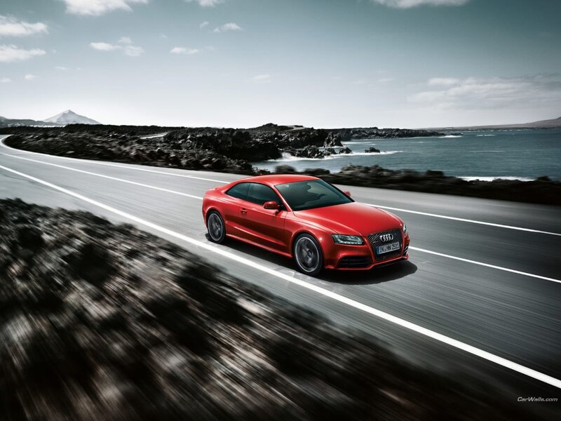 Red Audi driving on coastal road