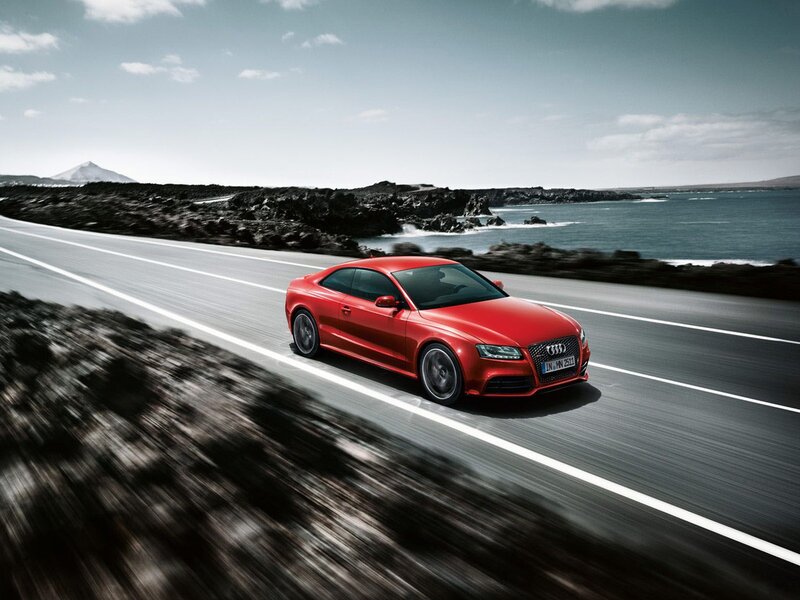 Red Audi driving on coastal road