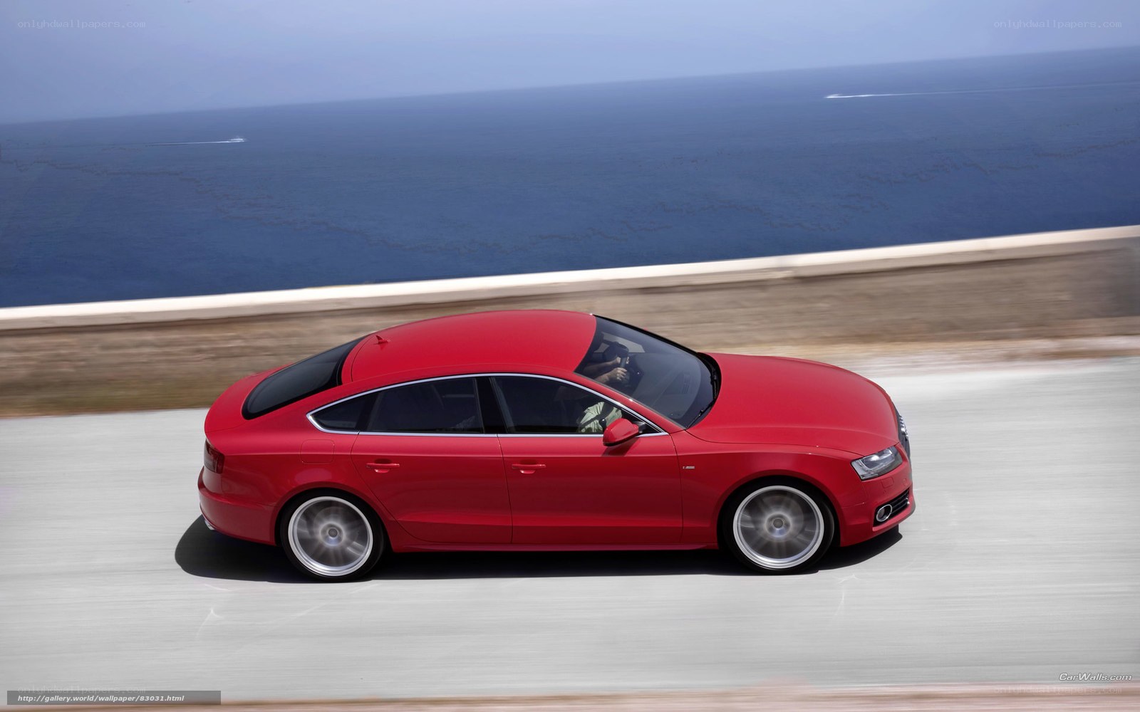 Red Audi driving on coastal road