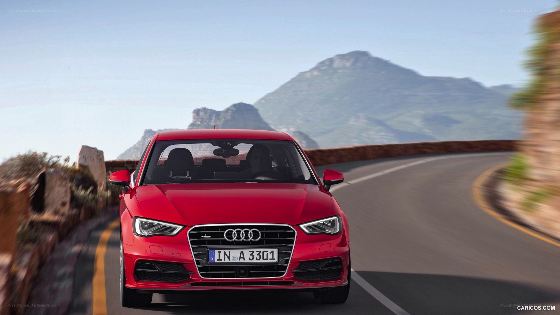 red audi driving on mountain road