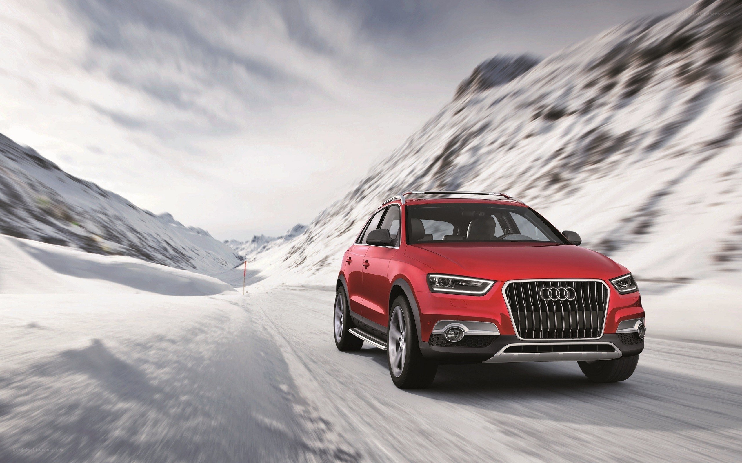 Red Audi on snowy mountain road