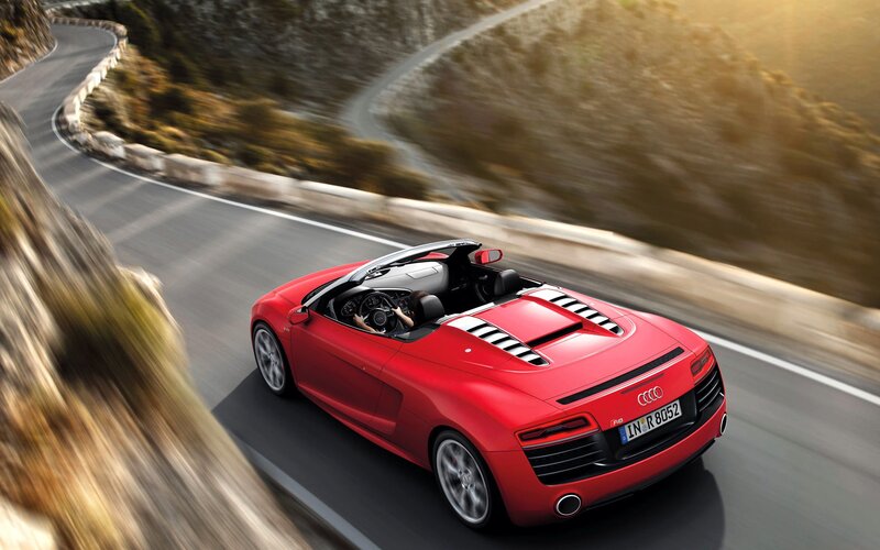 Red Audi R8 driving on mountain road