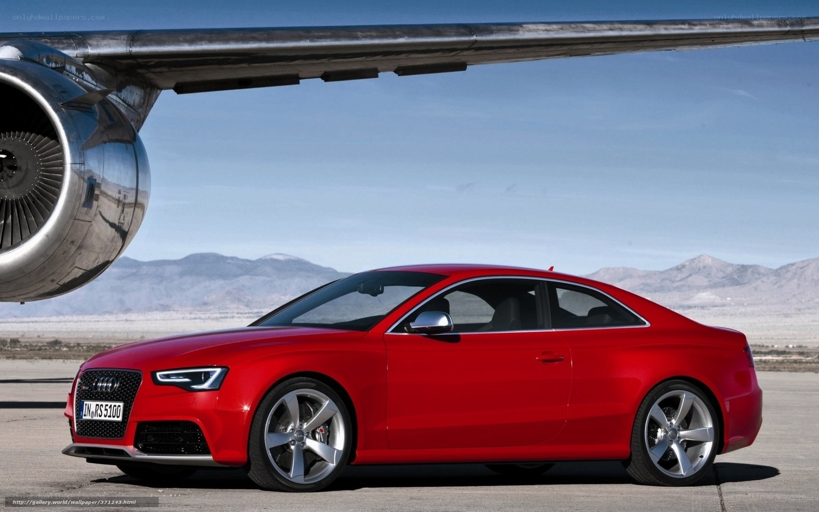 Red Audi RS5 under airplane wing