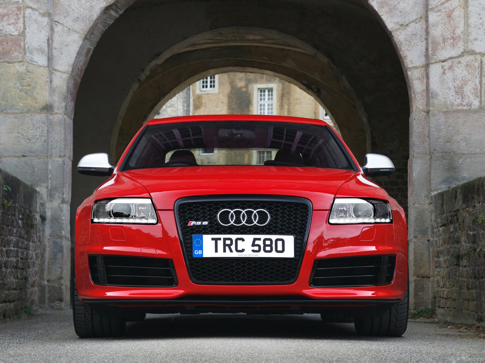 Red Audi RS6 under stone arch