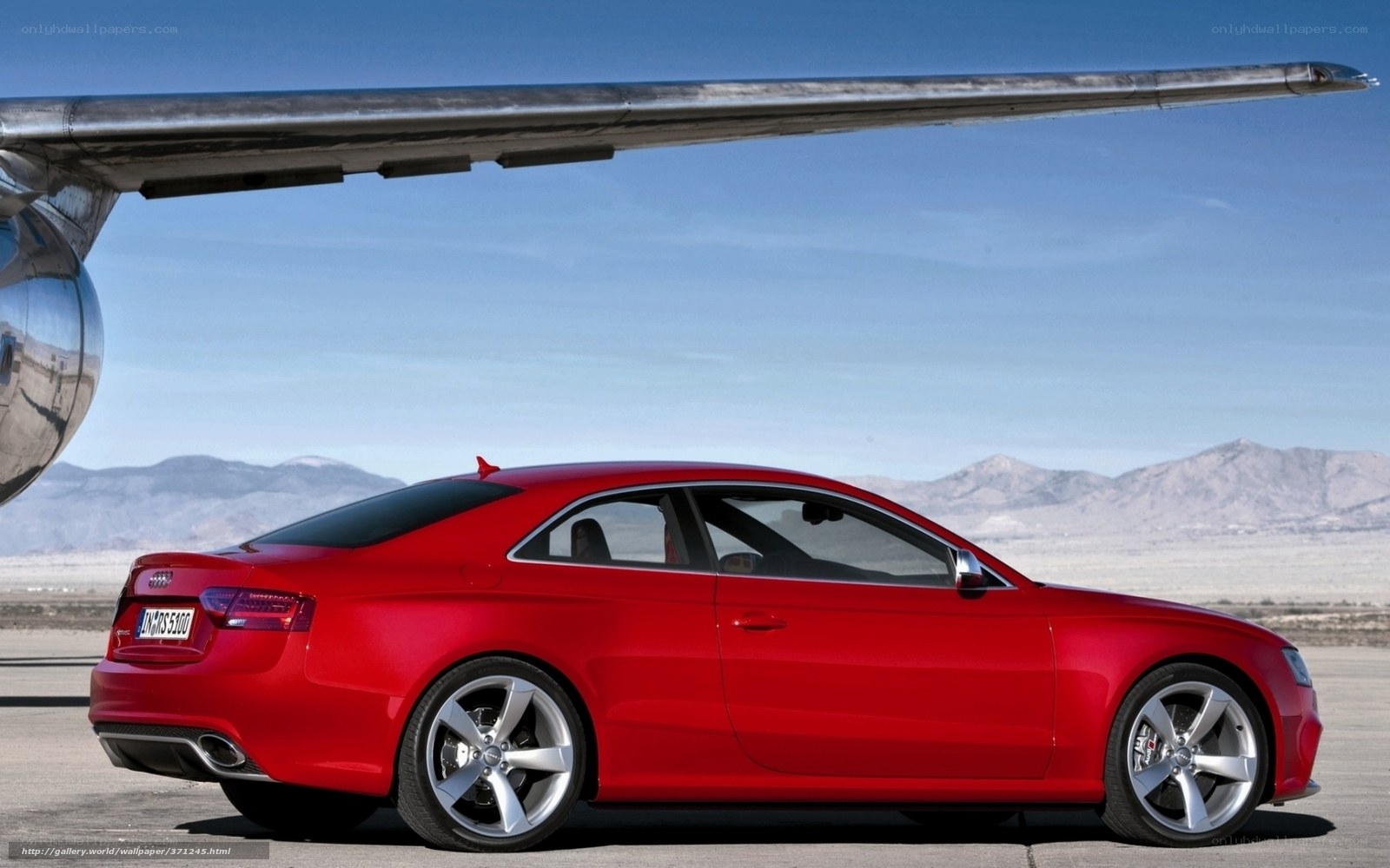 Red Audi S5 under airplane wing