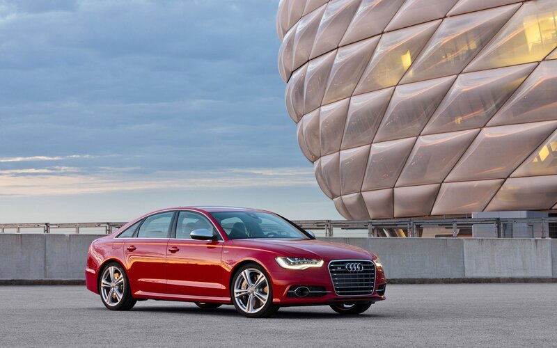 Red Audi S6 parked near modern building