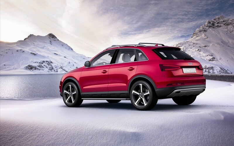 Red Audi SUV in snowy mountains