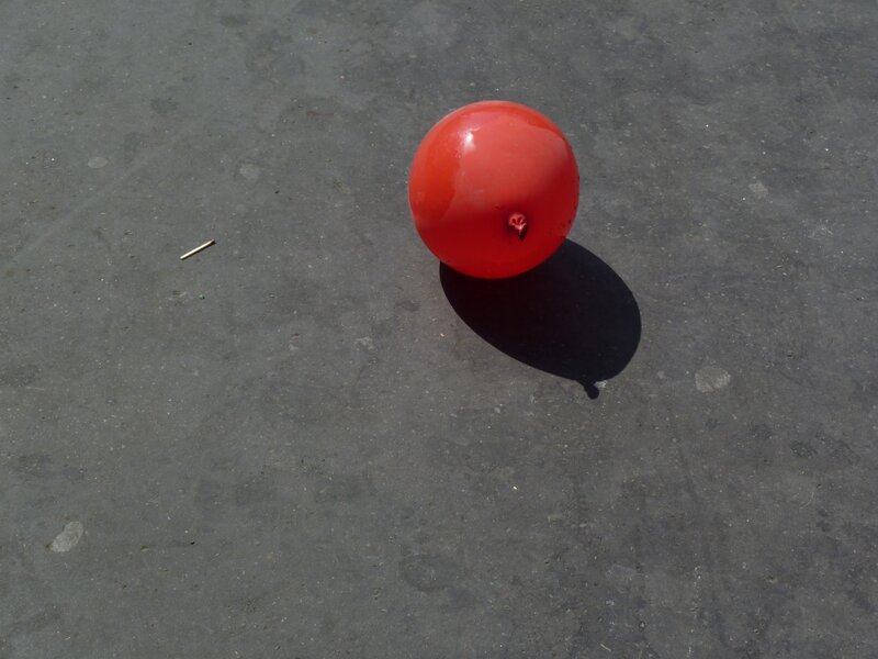 Red balloon on pavement