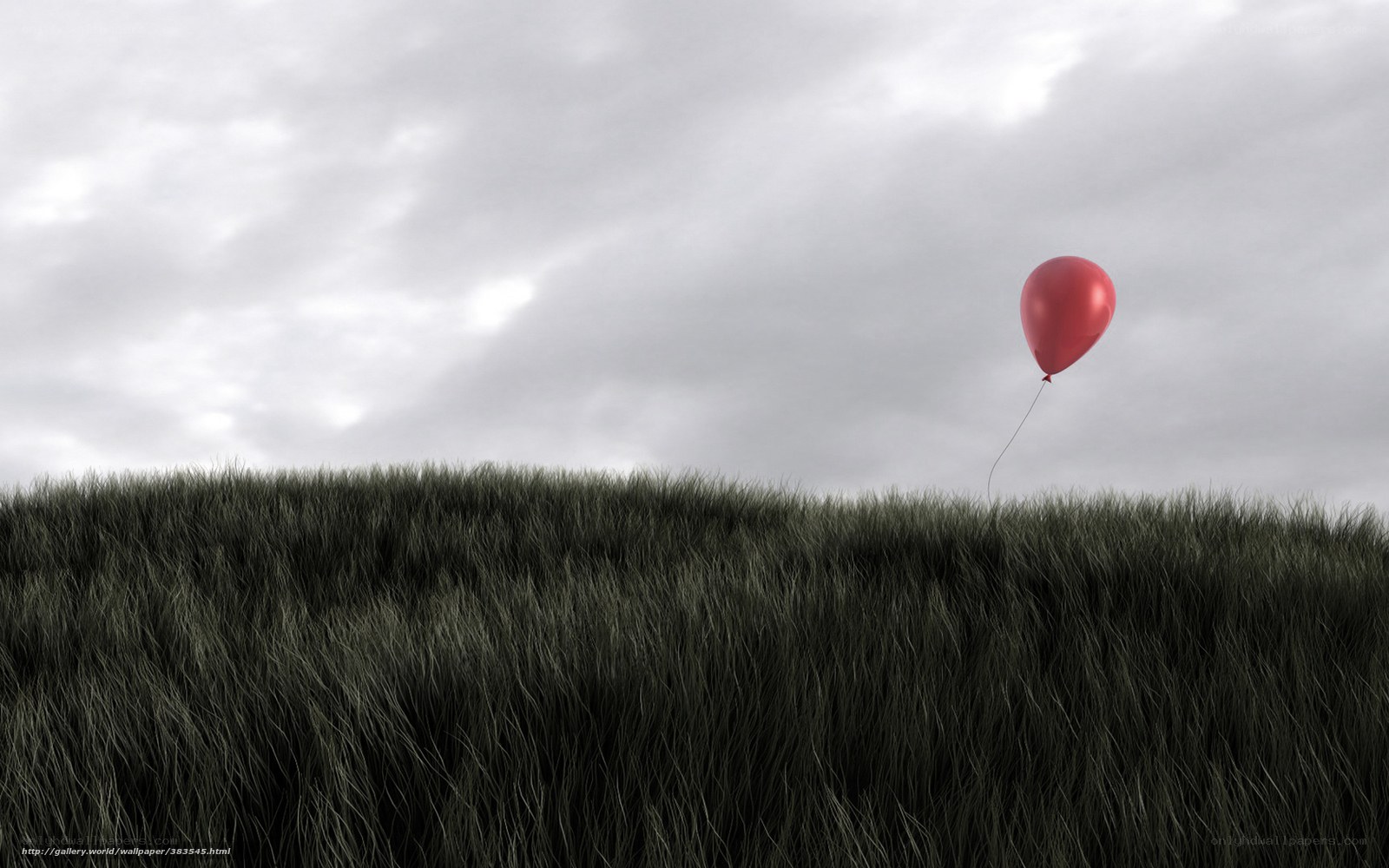 Red balloon over grassy hill