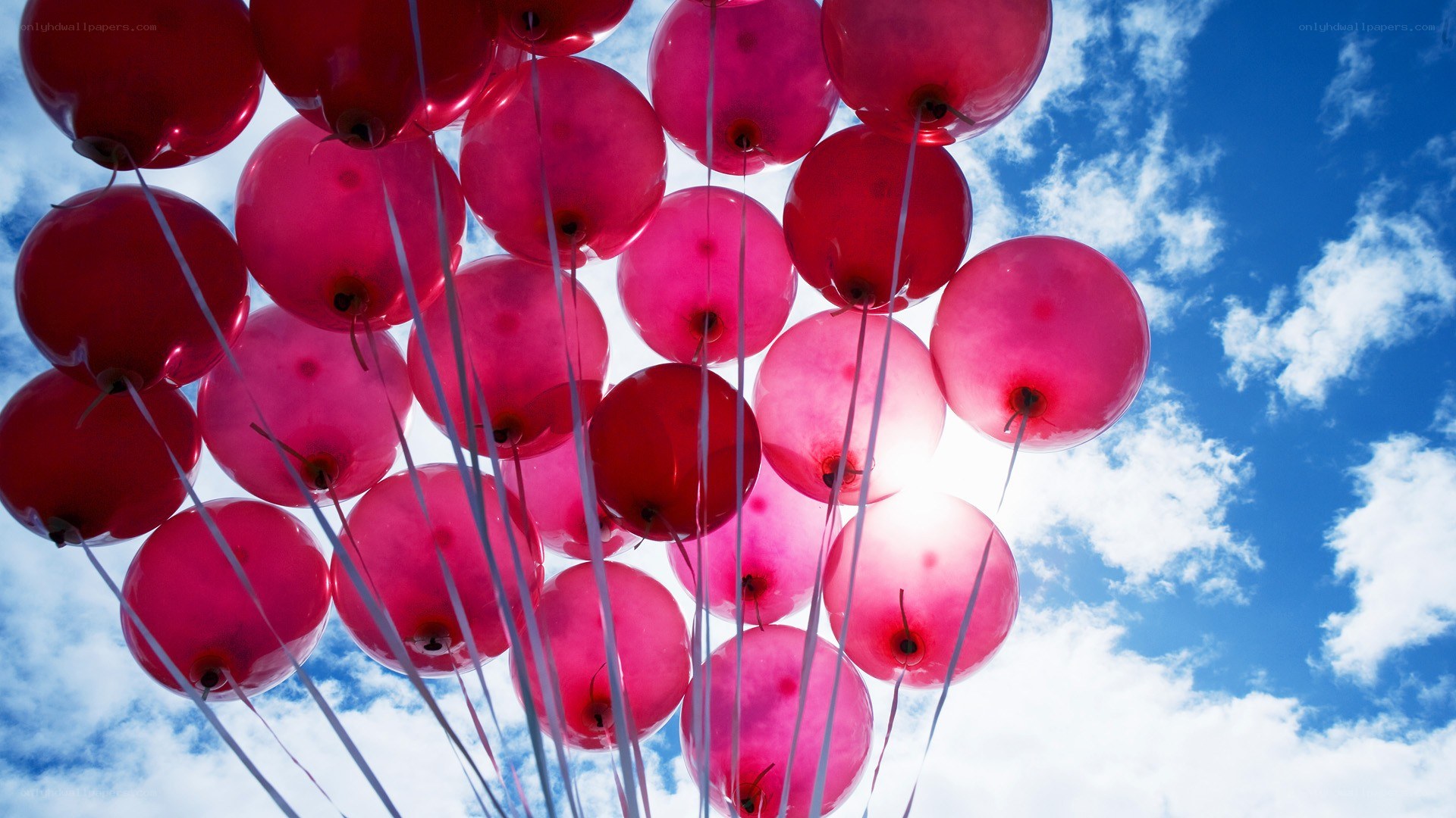 Red balloons against blue sky