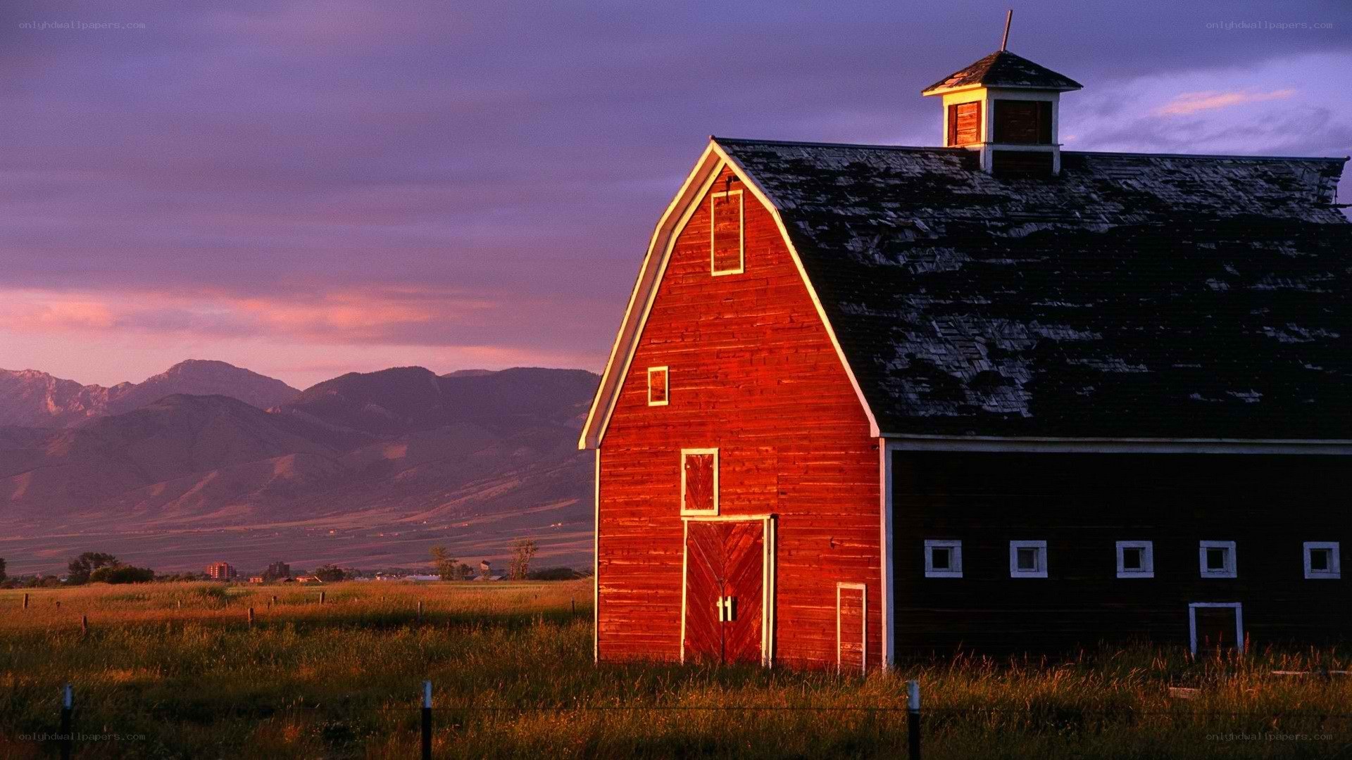 Red barn at sunset with mountains