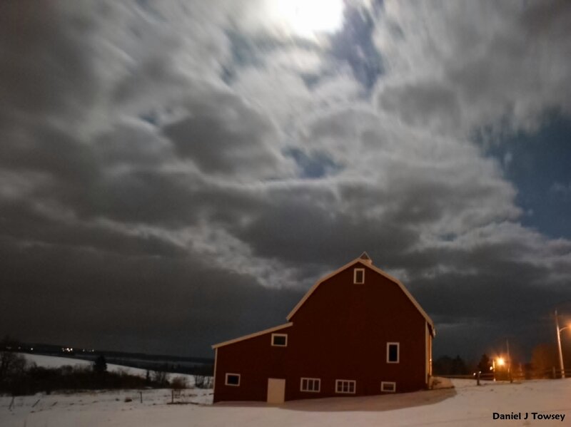 Red barn under cloudy night sky