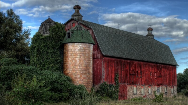 Red barn with silo and green roof