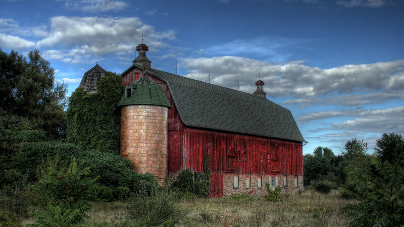 Red barn with silo in rural landscape