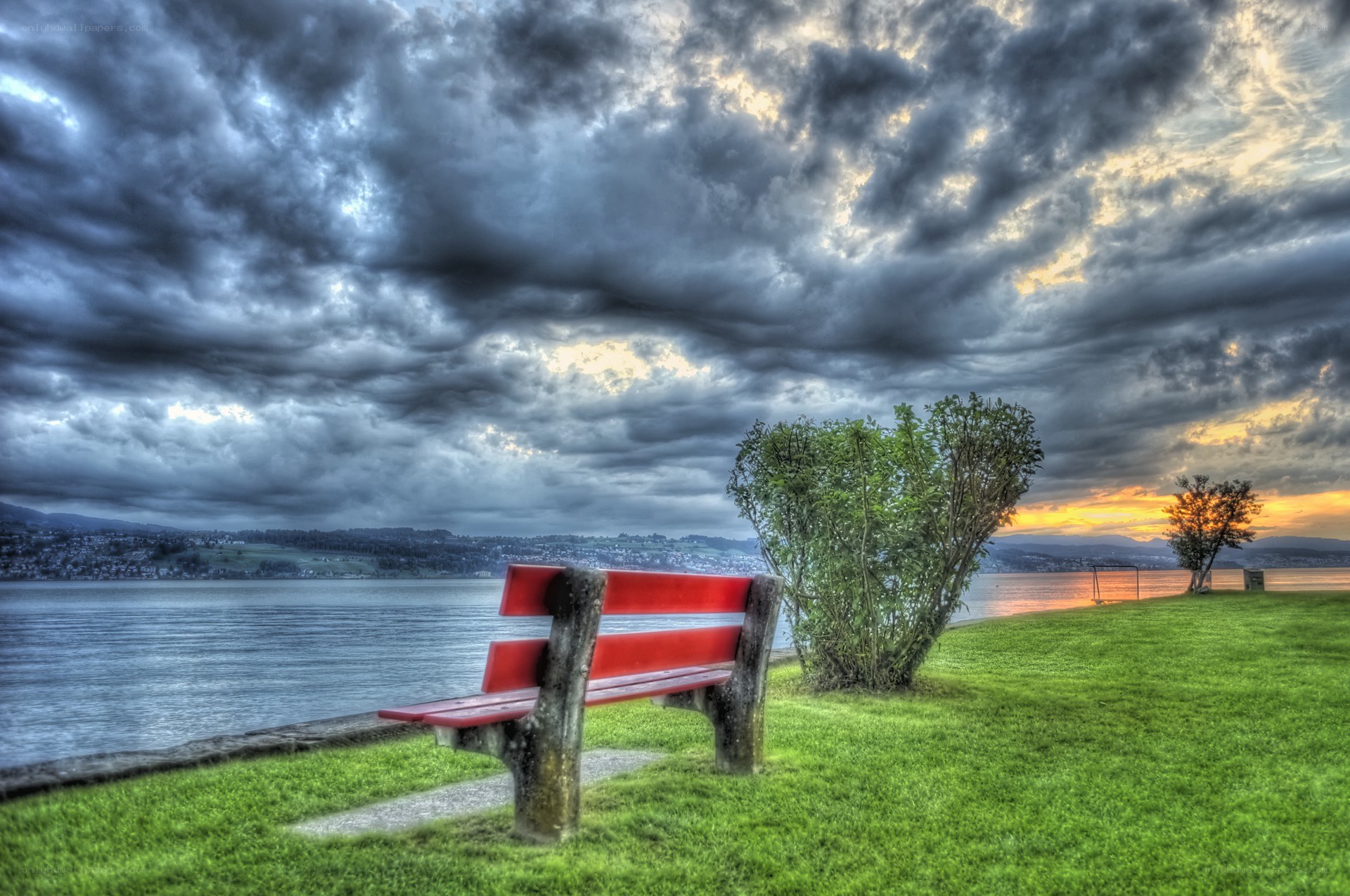 Red bench by the lake at sunset