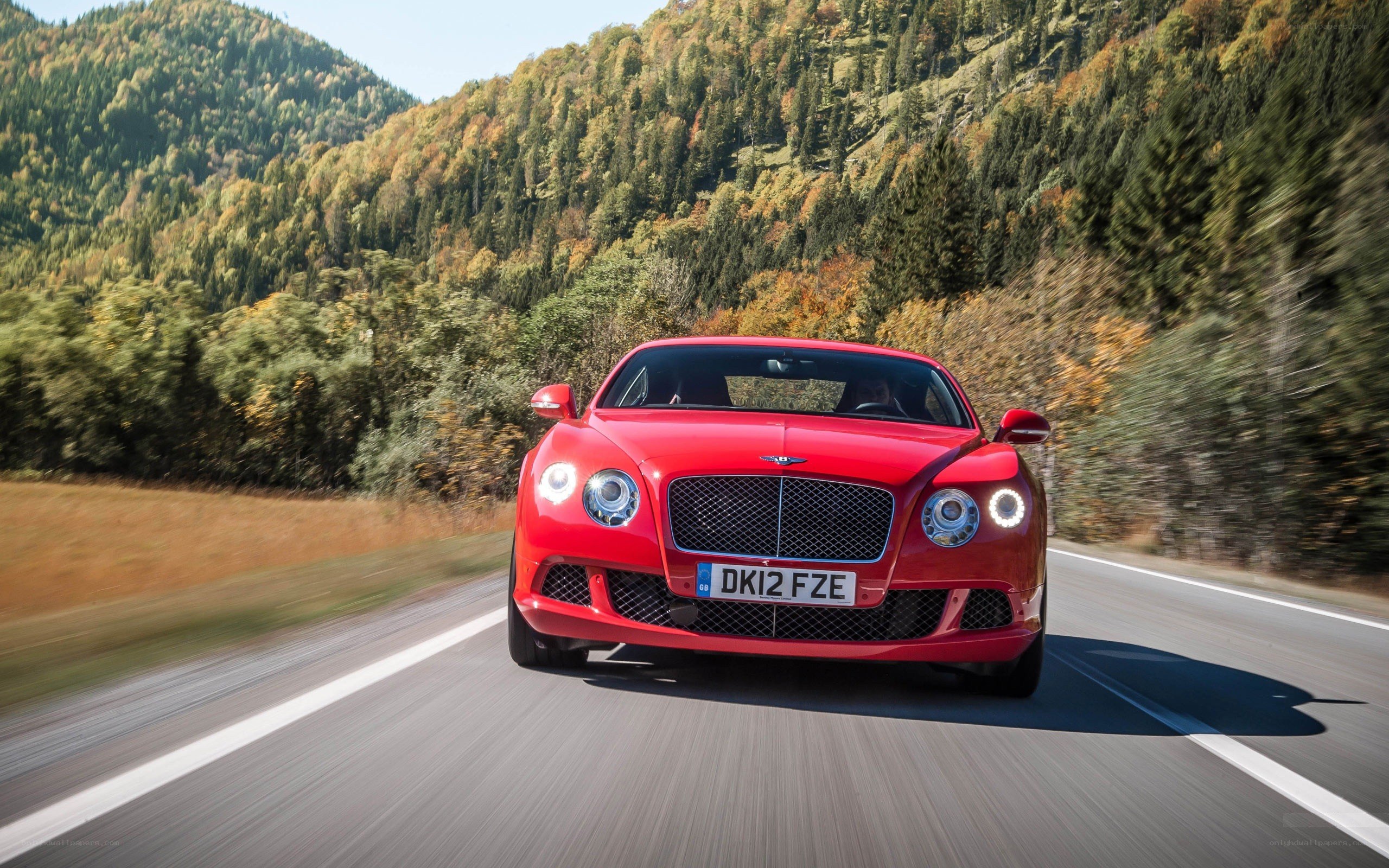 Red Bentley driving on a mountain road